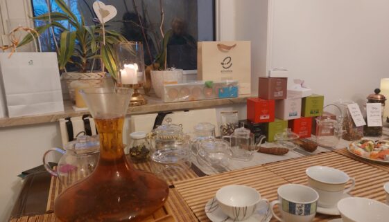 herbaty emotea na stole z filiżankami, akcesoriami do herbaty, torebkami puszkami z herbatą emotea