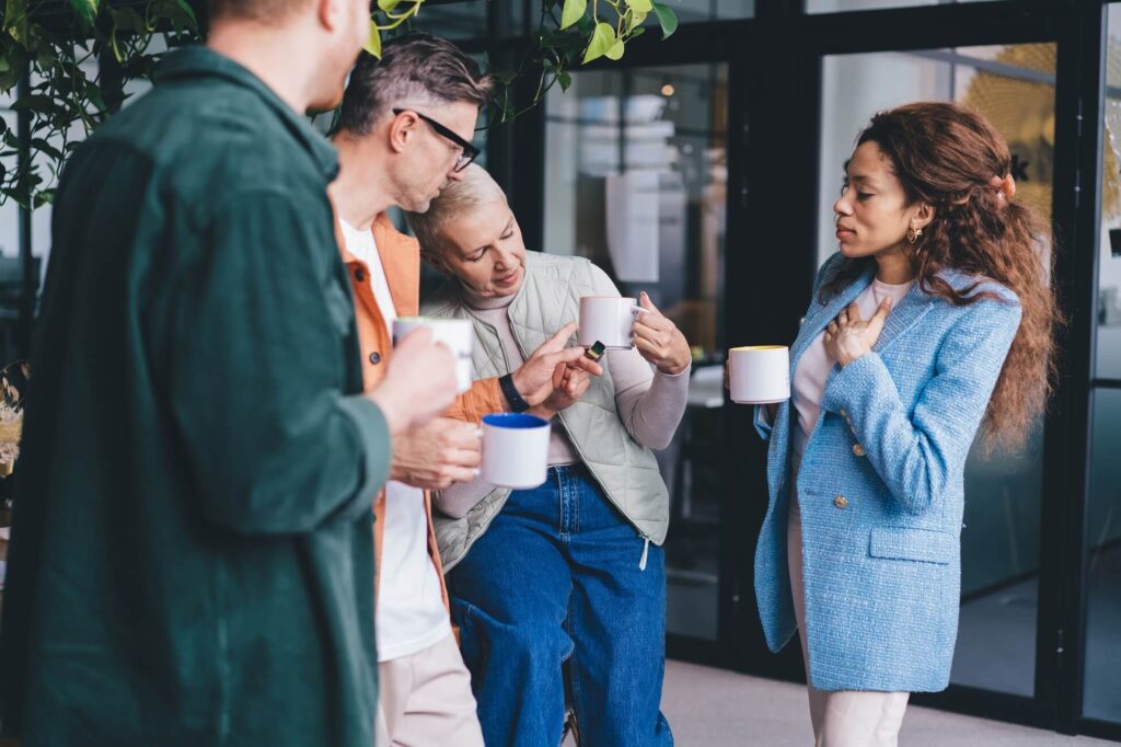 happy-diverse-colleagues-standing-with-coffee-cups-2024-05-13-17-17-43-utc (1)